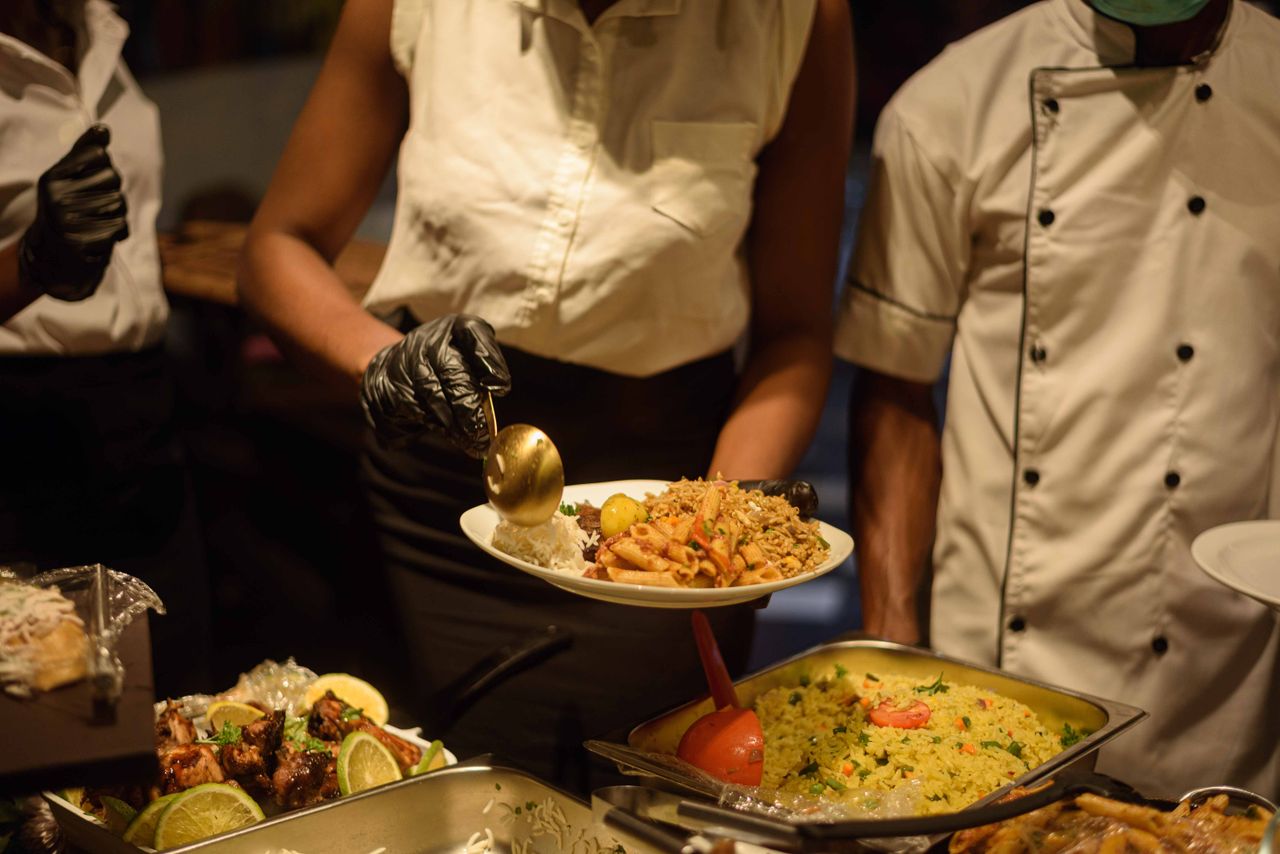 Catering service in Enugu, Nigeria with delicious buffet offerings served by staff.